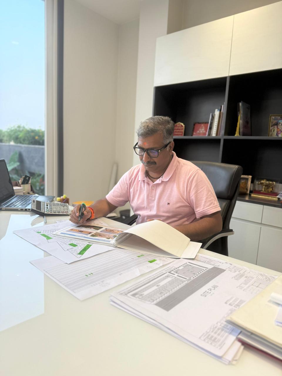 Ar. Sumit Agarwal reviewing architectural plans at his desk